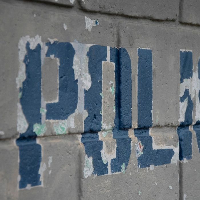 The work policia (police in Spanish) painted on a gray wall. 