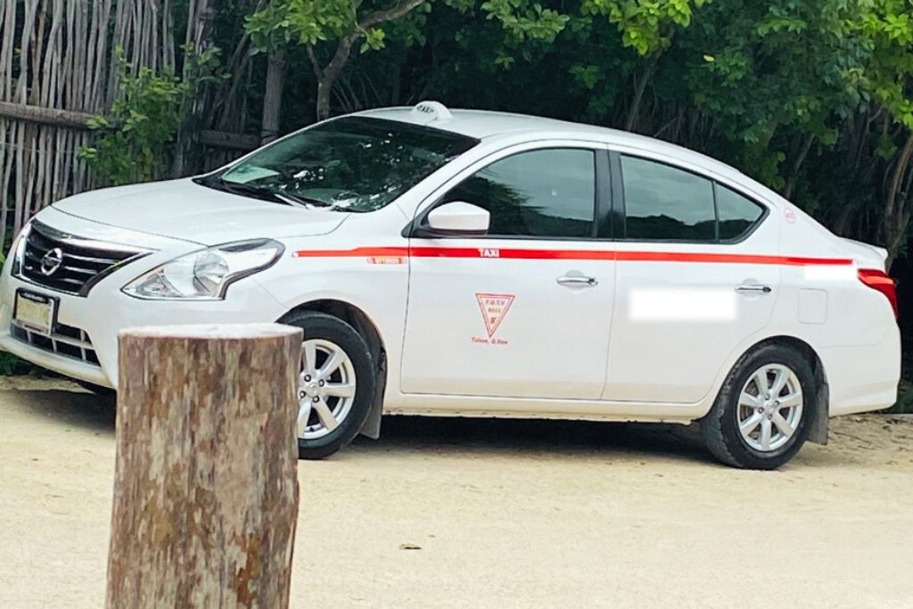 A red and white Tulum taxi